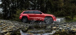 2021 Red Jeep Grand Cherokee Driving Through a Puddle